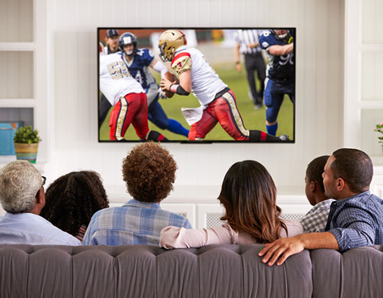 A family gathered on the couch watching football in prime time